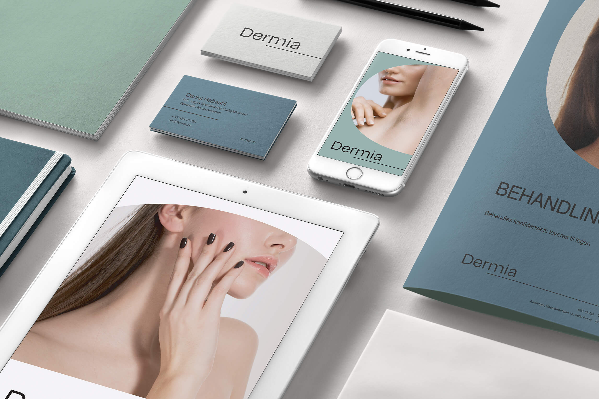 Mockup med eksempler på ny profil for Dermia hudklinikk, som viser nettside, visittkort, trykksaker med mer