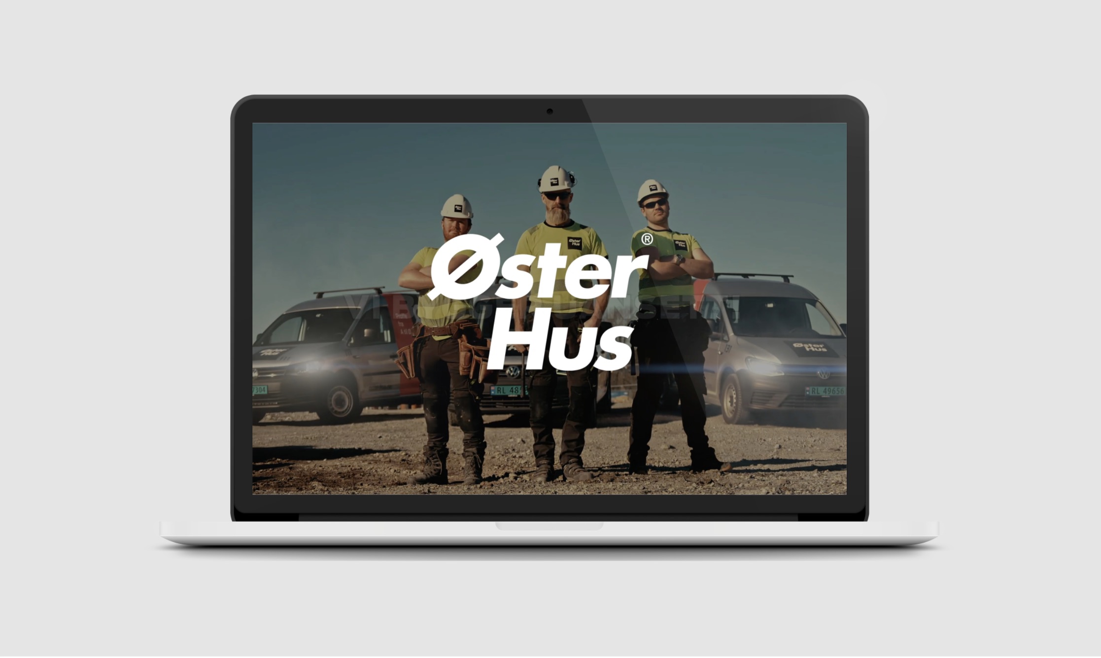 Datamaskin med Øster Hus logo i senter og bakgrunnsbilde av de tøffe medarbeiderne som representerer laget bak løftet 